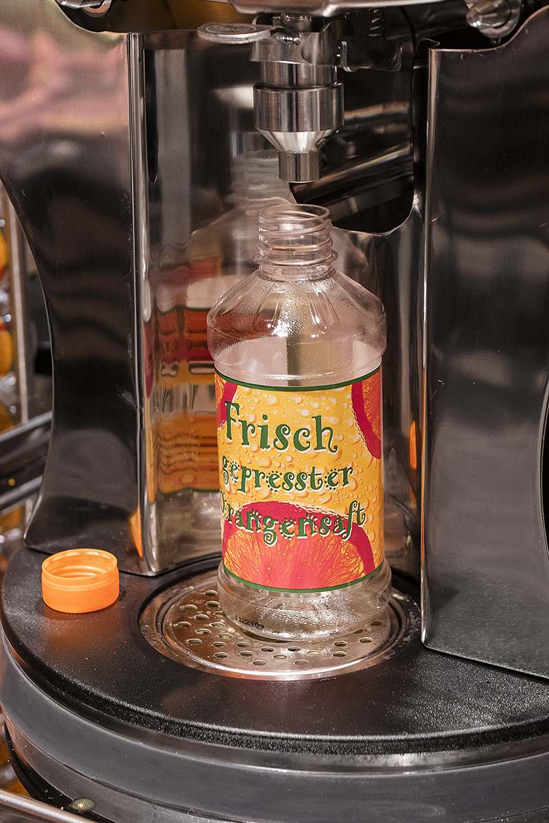 Flasche unter Orangensaftautomat