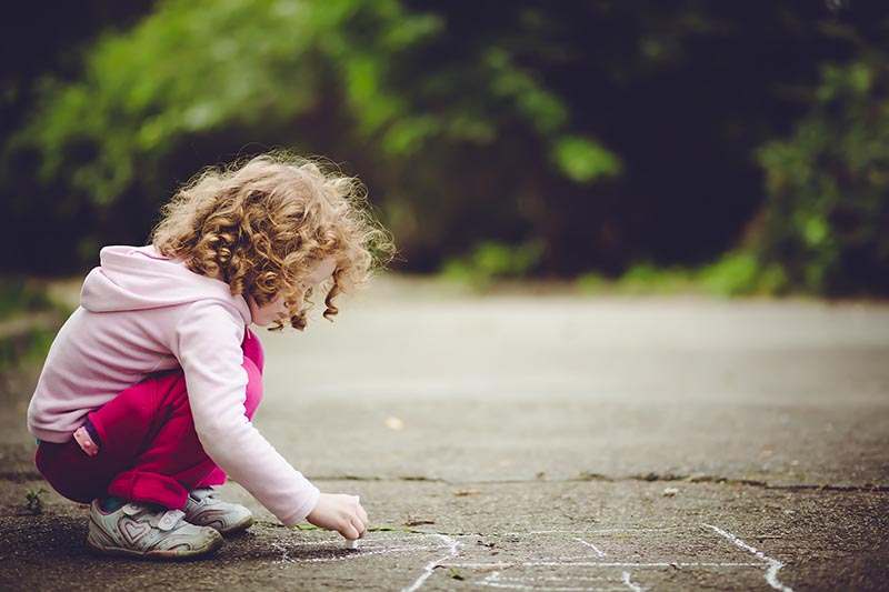 Child draws on asphalt