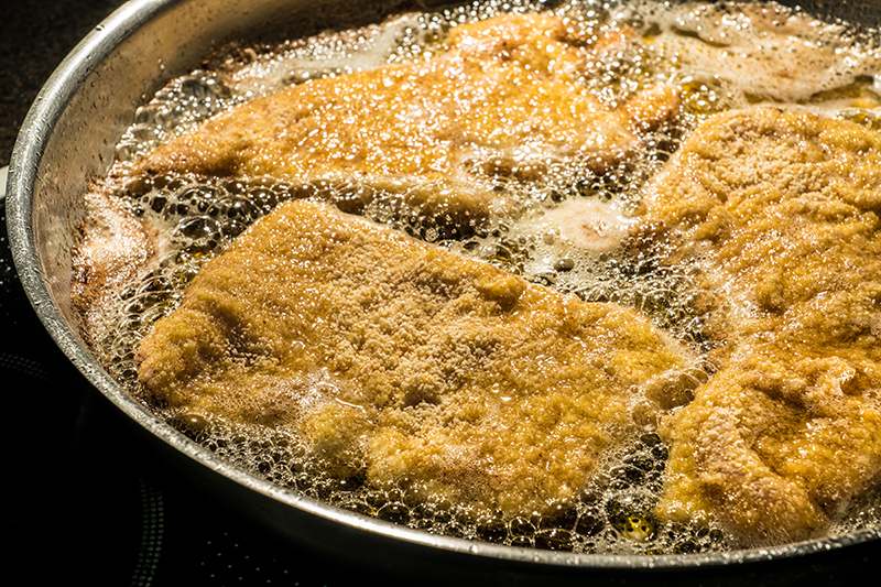 Paniertes Schnitzel in der heißen Bratpfanne