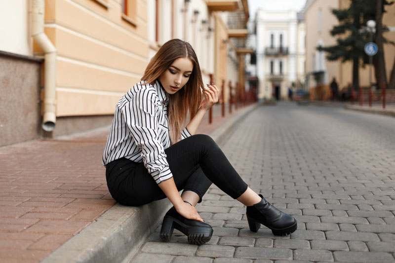 Frau mit Bluse auf Bordstein